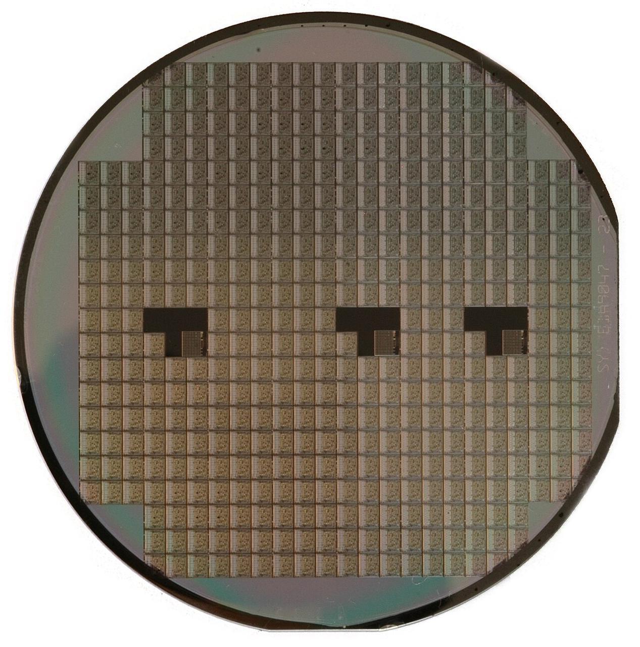 A silicon wafer with an array of integrated circuit dies, the physical foundation of Moore's Law