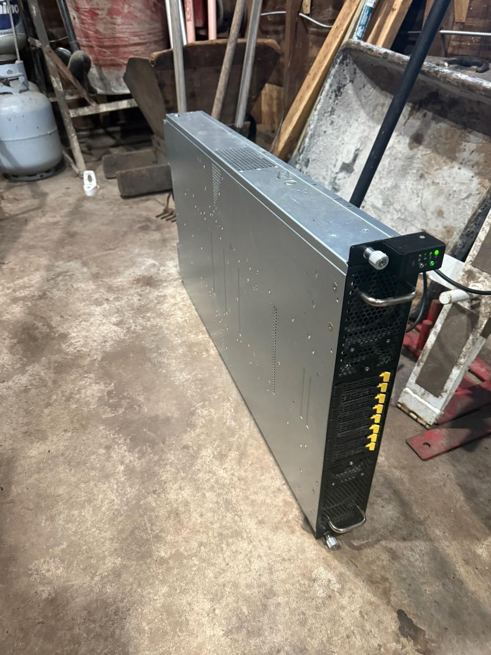 The Tesla P40 server standing on its side in an unheated Minnesota shop building — one of three machines benchmarked for local TTS generation