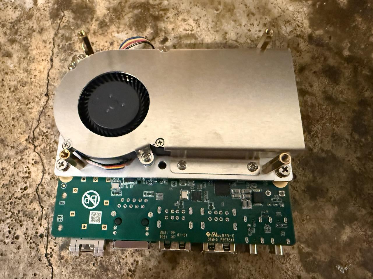 Underside of the SpacemiT K3 showing a large aluminium heatsink with an integrated blower fan bolted over the board