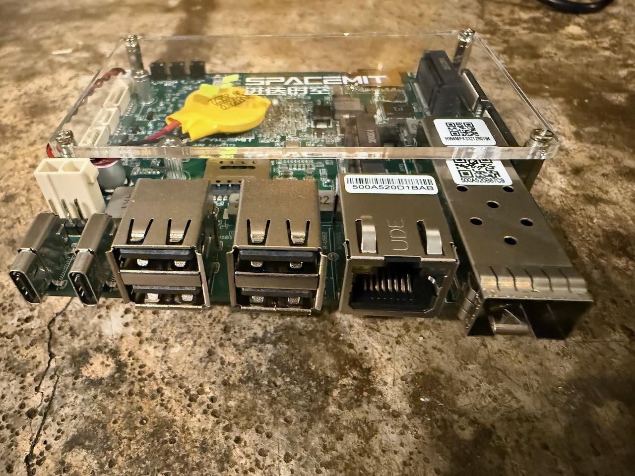 Port edge of the SpacemiT K3 showing two USB-C connectors, four USB-A ports in two stacks, a gigabit Ethernet jack and an SFP cage